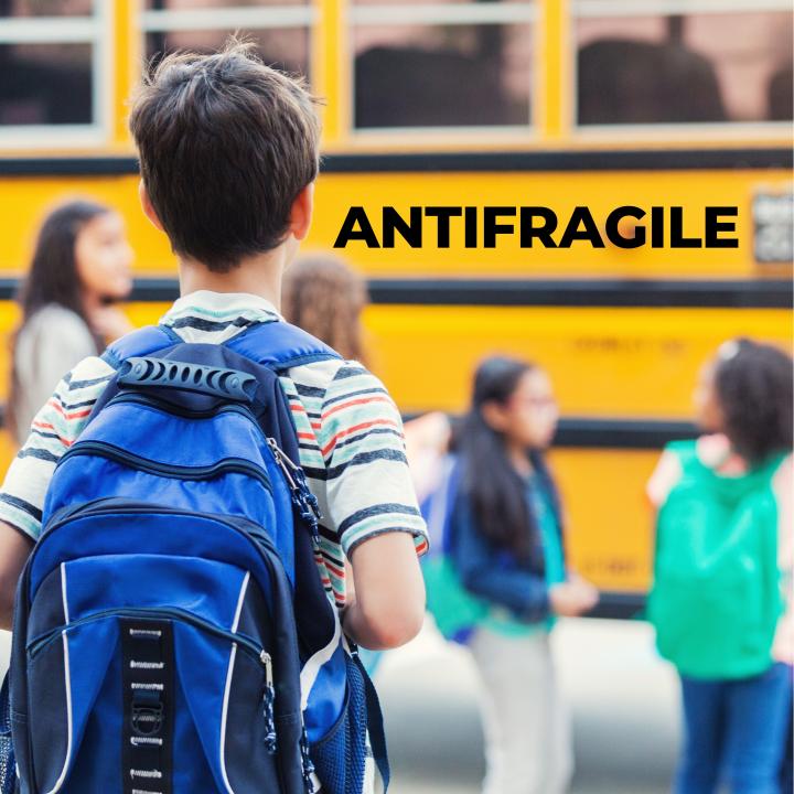 child with a backpack waiting on the school bus