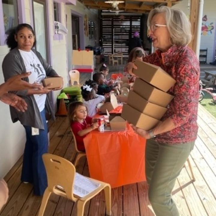 woman carrying boxed lunches