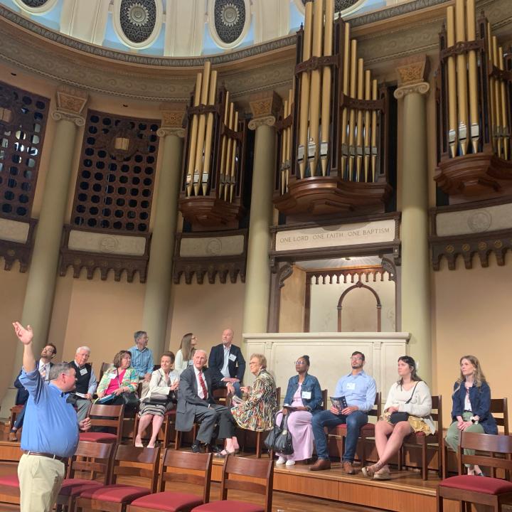 group of people sitting in the south main choir loft looking at the sanctuary